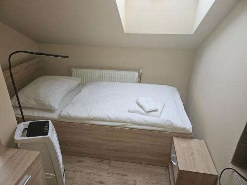 オストラヴァにあるHotel Taurusの小さなベッドルーム(白いシーツ付きのベッド1台付)