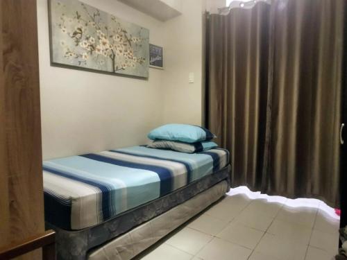 a small bed in a room with a curtain at A cozy, relaxing condo at city center in Davao City