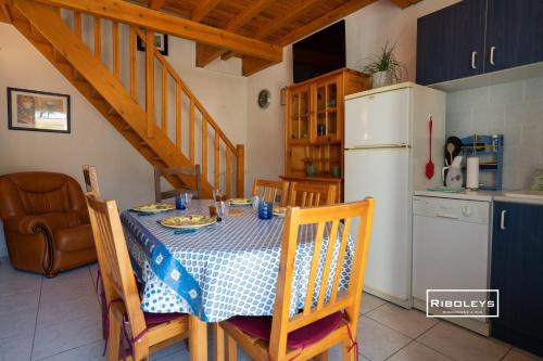 une cuisine avec une table et un réfrigérateur blanc dans l'établissement Maison climatisée à 600m de la plage, à Vias