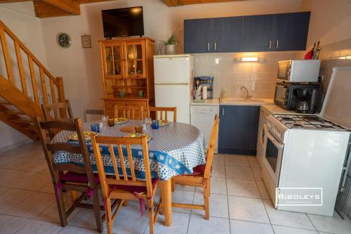 - une cuisine avec une table, des chaises et une cuisinière dans l'établissement Maison climatisée à 600m de la plage, à Vias