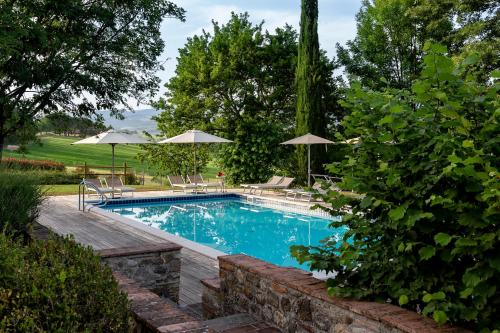 einen Pool mit Stühlen und Sonnenschirmen im Hof in der Unterkunft Villa Colonica Tuori at Tenuta Schifanoia in San Piero a Sieve