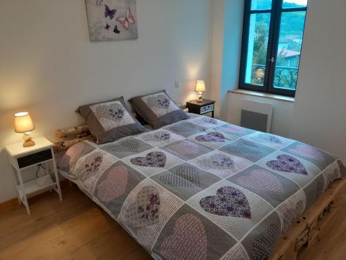 a bedroom with a bed and two lamps on tables at Au Bien-hêtre in Granges-sur-Vologne