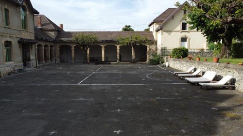 an empty parking lot with white seats in a building at L'école buissonnière in Laroque-dʼOlmes