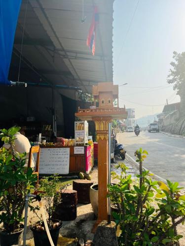 a stand on the side of a street with plants at 1 Min to Slow Boat Guesthouse in Ban Khonkèo