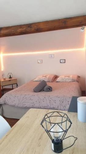 une chambre avec un lit et une table en bois dans l'établissement Le cocon de David, à Alès