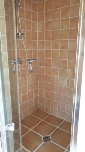 une douche avec une porte vitrée dans une salle de bain dans l'établissement Le cocon de David, à Alès