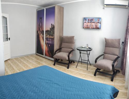 a room with two chairs and a table at Smart Apartment на Соборной 23 in Kremenchuk