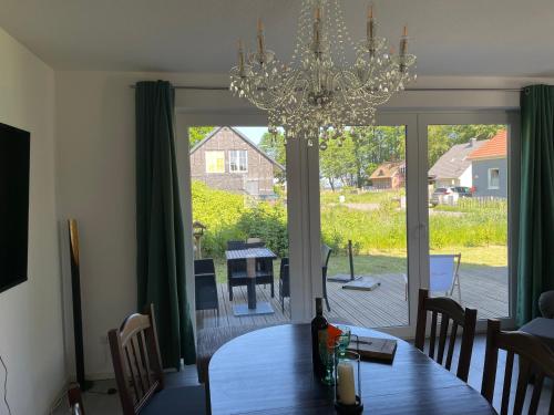 a dining room with a table and a chandelier at Ferienhaus am Nationalpark, Klausdorf, ca 250m bis zur Badestelle in Klausdorf Mecklenburg Vorpommern