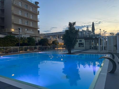 een groot blauw zwembad voor een gebouw bij HOTEL NOVECENTO in Cattolica