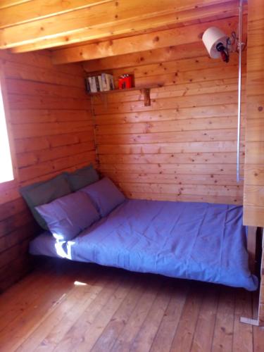 a room with a bed in a wooden cabin at Romantic Mountain cabin with Spa in Caserío Carraspite