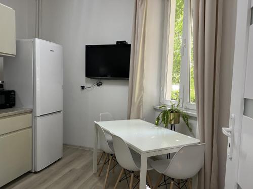 a kitchen with a white table and a white refrigerator at Mieszkanie w rynku in Wrocław