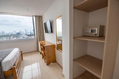a hotel room with a bed and a microwave at Hotel Stil Cartagena in Cartagena de Indias