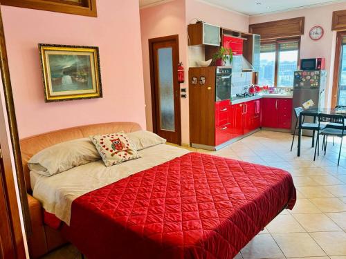 een slaapkamer met een rood bed en een keuken bij Napoli Centro in Napels