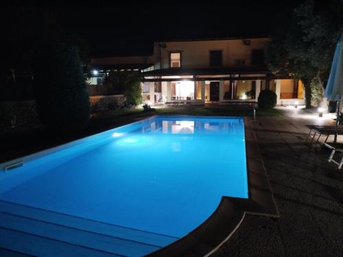 a swimming pool at night in front of a house at San Domenico Residence in Arenella