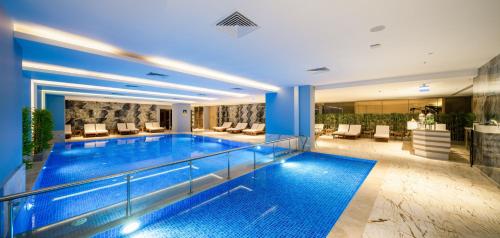 a large swimming pool in a hotel with blue lighting at Concorde Tower Hotel & Casino in North Nicosia