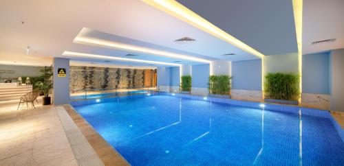 a large swimming pool in a hotel room with a pool at Concorde Tower Hotel & Casino in North Nicosia