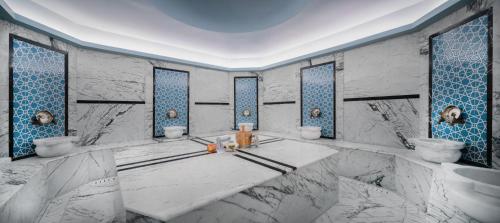 a bathroom with two sinks and blue and white tiles at Concorde Tower Hotel & Casino in North Nicosia