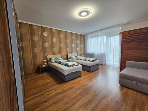 a living room with two beds and a couch at Mantra Wellness Apartments in Dunajská Streda