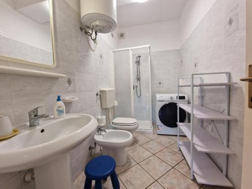 a white bathroom with a sink and a toilet at Appartamenti Fetovaia Orchidea in Fetovaia