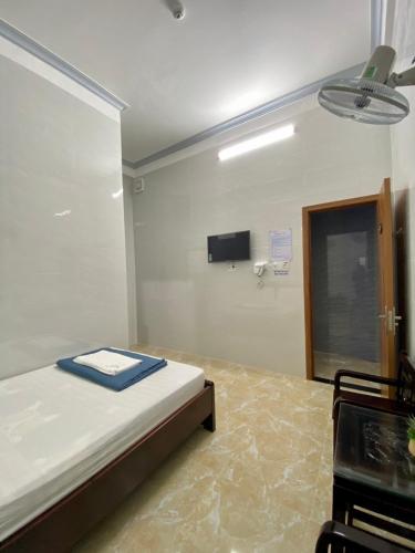 a bedroom with a bed and a tv on the wall at Nhà Nghỉ Thiên Tân 2 in Quang Ngai