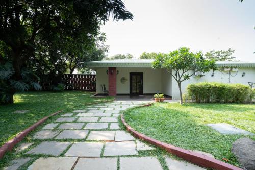 a garden with a stone path in front of a house at The Greenfields Resort and Convention in Venkatāpur