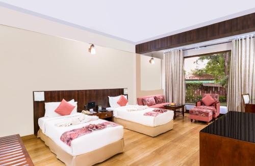 a bedroom with two beds and a living room at Trance Greenfields Resort and Convention Centre in Venkatāpur