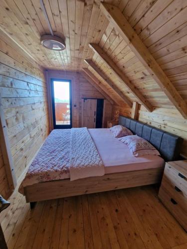 a bedroom with a bed in a wooden cabin at Bungalovi Spahic in Ulcinj