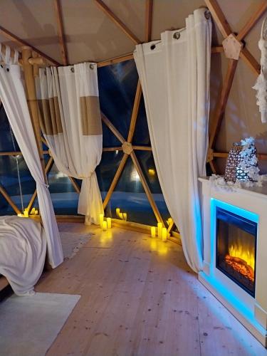 a room with a fireplace and curtains in a tent at Le Clos FMR Insolite - "F"anny Carcassonne in Malves-en-Minervois