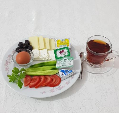 um prato de comida com queijo e legumes e uma chávena de chá em Kardelen Otel em Bodrum City