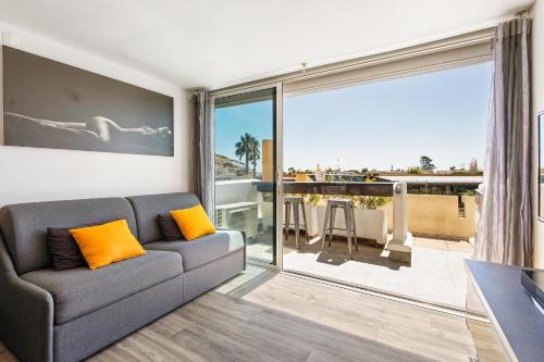 un salon avec un canapé et une grande fenêtre dans l'établissement Village Naturiste r4n - Dream PN 5 coursives, au Cap d'Agde