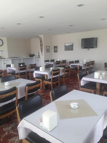 a dining room with white tables and chairs at OTEL AMİLLER in Erzurum
