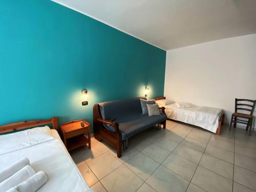 a bedroom with two beds and a couch and a chair at Agriturismo San Giuliano dei fratelli Giai in Susa