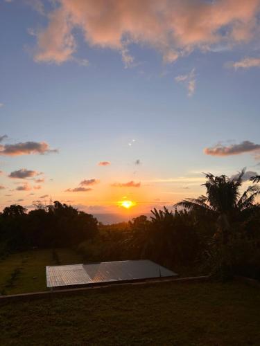 a sunset with the sun setting in the sky at Logement Émeraude in Sainte-Rose