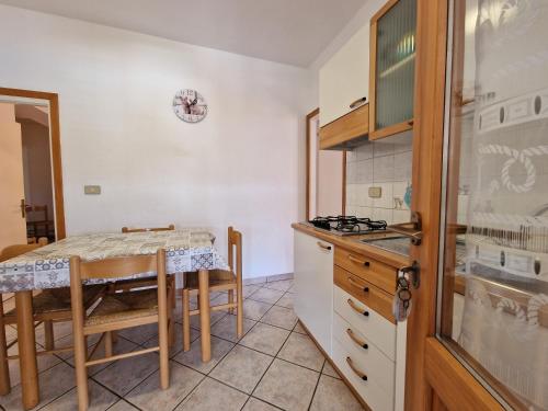 a kitchen with a table and a small kitchen with a table and chairs at Appartamenti Fetovaia Elicriso in Fetovaia