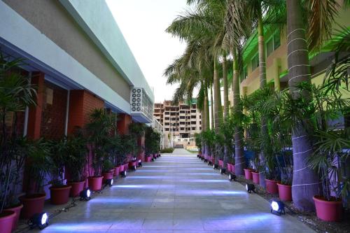 a hallway of a building with palm trees and lights at Hotel Haldi in Nashik