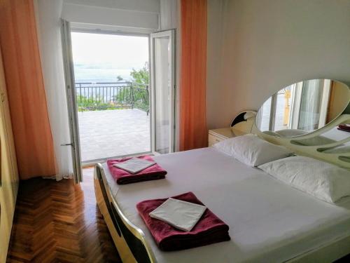 a bedroom with a bed with a mirror and a window at Apartman TRALJE in Senj