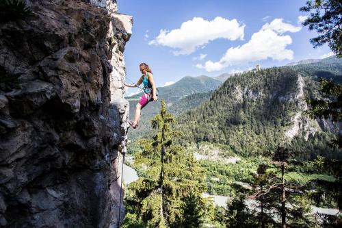a woman is rappelling off of a cliff at Lechtaler Alpenblick Landeck - Privatzimmer & Ferienwohnung in Landeck
