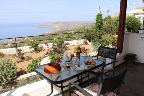 uma mesa com comida e vista para o oceano em Roussa's View Apartments em Sitia