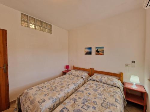 una camera con un letto e due comodini di Appartamenti Fetovaia Lavanda a Fetovaia