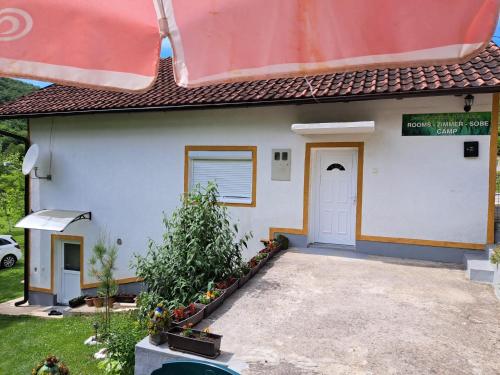a small white house with a white door at Seosko domacinstvo Halil & Alema in Ćukovi