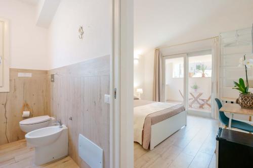 y baño con cama, aseo y lavamanos. en Domo Green House en Villasimius