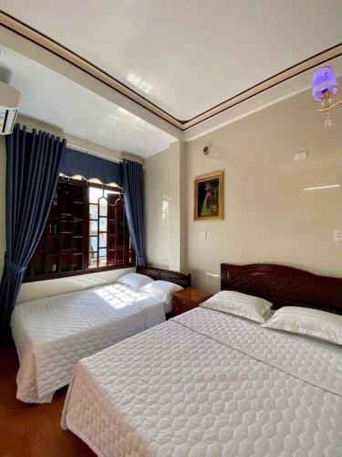 a bedroom with two beds and a window at Nhà Nghỉ Thiên Tân 2 in Quang Ngai