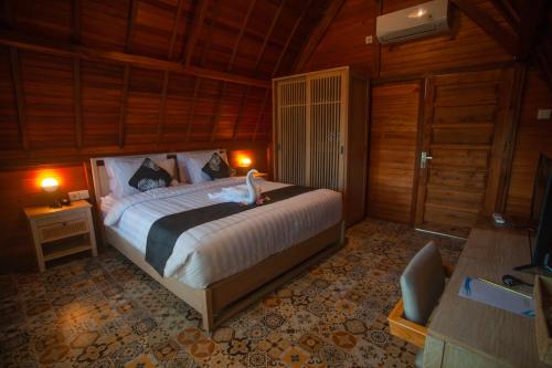 - une chambre avec un lit et une télévision dans l'établissement Plumeria NP, à Nusa Penida