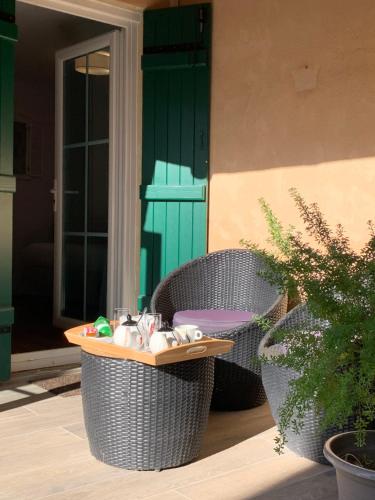 two wicker chairs and a table on a patio at AUBERGE DU PORCHE in Blaye