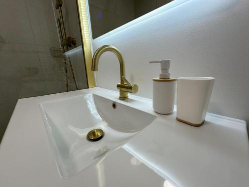 d'un évier avec un robinet et deux tasses dessus dans l'établissement Le Panoramic, à Villeurbanne