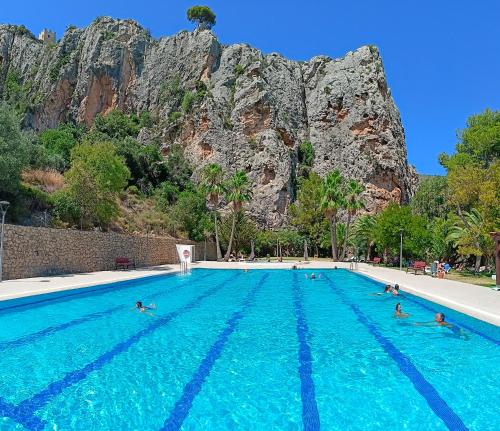 a group of people swimming in a large swimming pool at Guadalest Panorama in Guadalest
