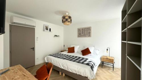 ein weißes Schlafzimmer mit einem Bett und einem Tisch in der Unterkunft Maison LAURENTZENIA in Saint-Jean-Pied-de-Port