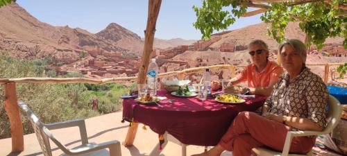 a man and a woman sitting at a table with food at Gorges View Dades in Tamellalt