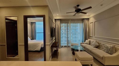 ダナンにあるDa Nang Ocean View Luxury Apartmentのリビングルーム(ソファ付)、ベッドルーム1室が備わります。