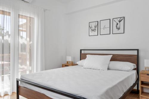 a white bedroom with a bed and a window at Sea La Vie in Nikiana